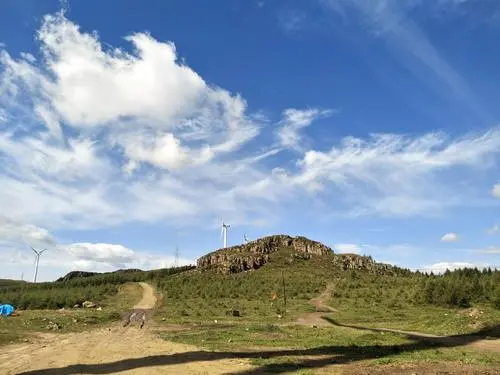 很突兀地矗立在草原天路一侧平缓浑圆的丘陵中,是鬼斧神工般的石头